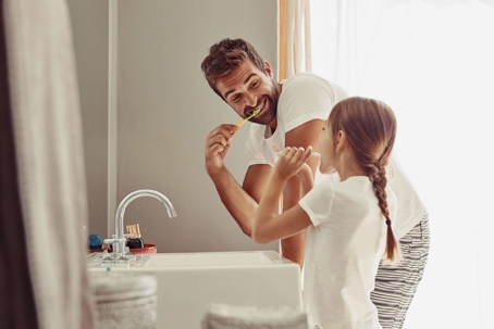 father and daughter brushing teeth